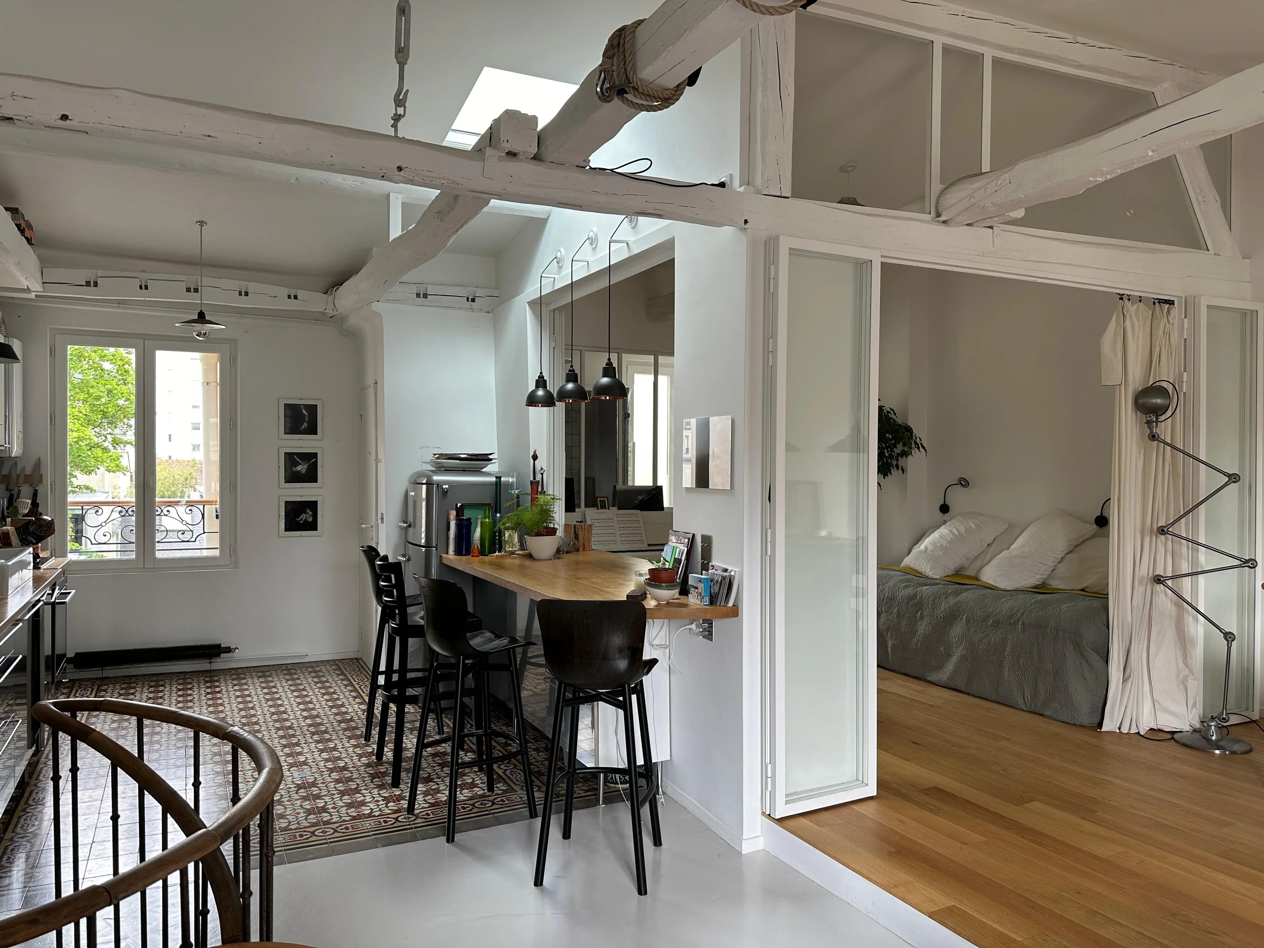 Espace ouvert avec bar central et poutres apparentes, duplex Paris 19e