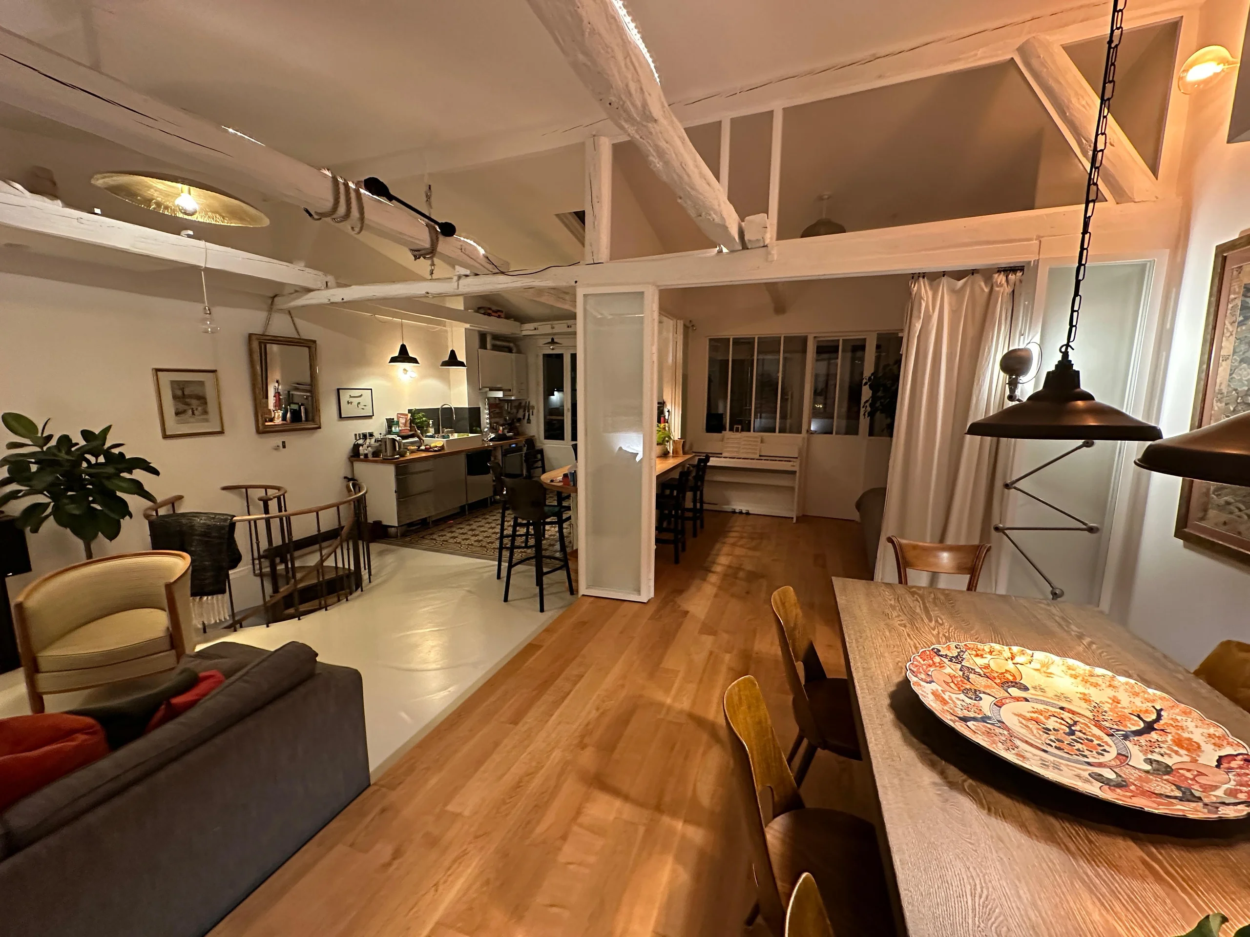 Grand espace de vie avec cuisine ouverte et poutres apparentes, duplex Buttes-Chaumont