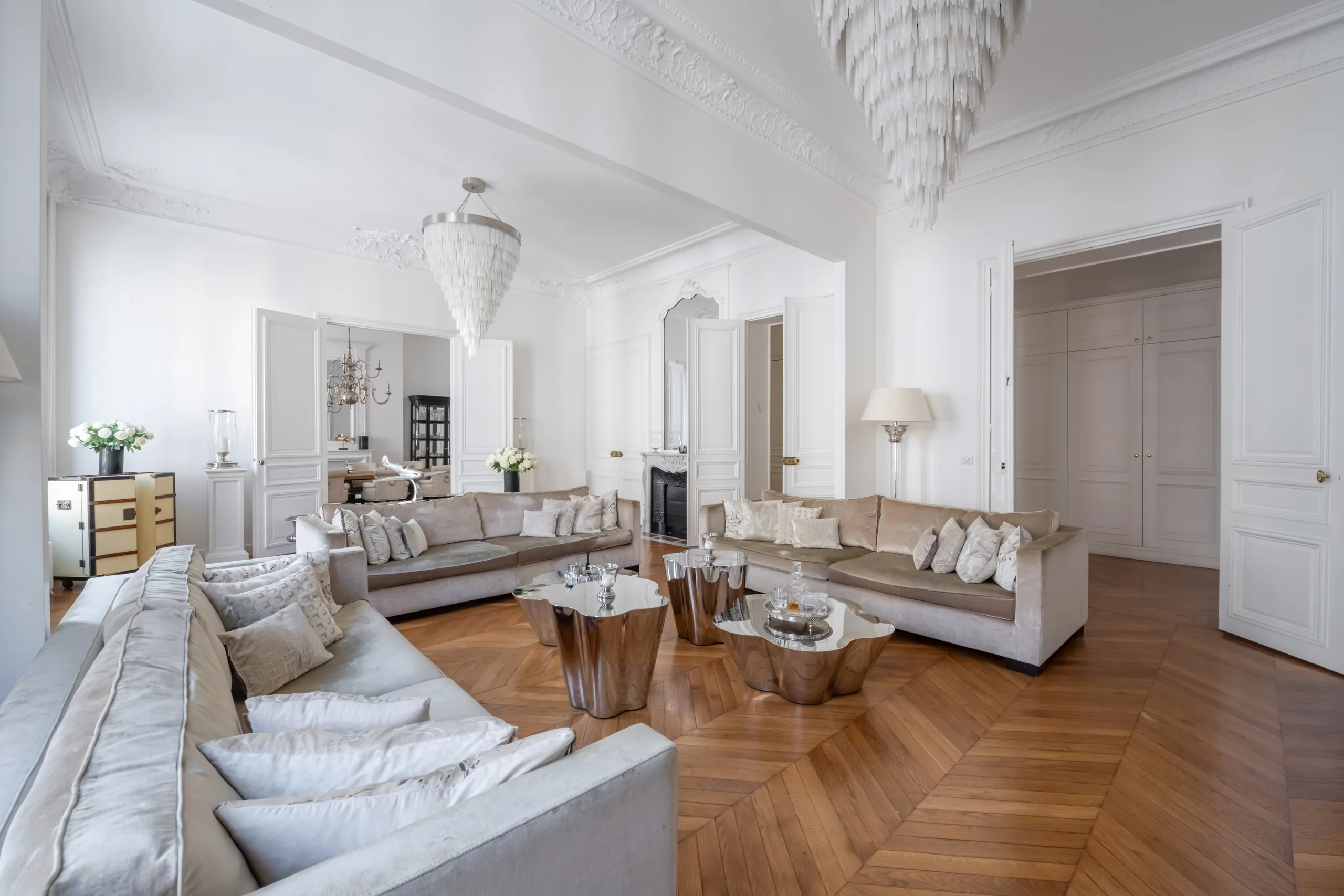 Grand salon haussmannien 240 m² avec parquet à chevrons et lustre à pampilles, Paris 17e Courcelles