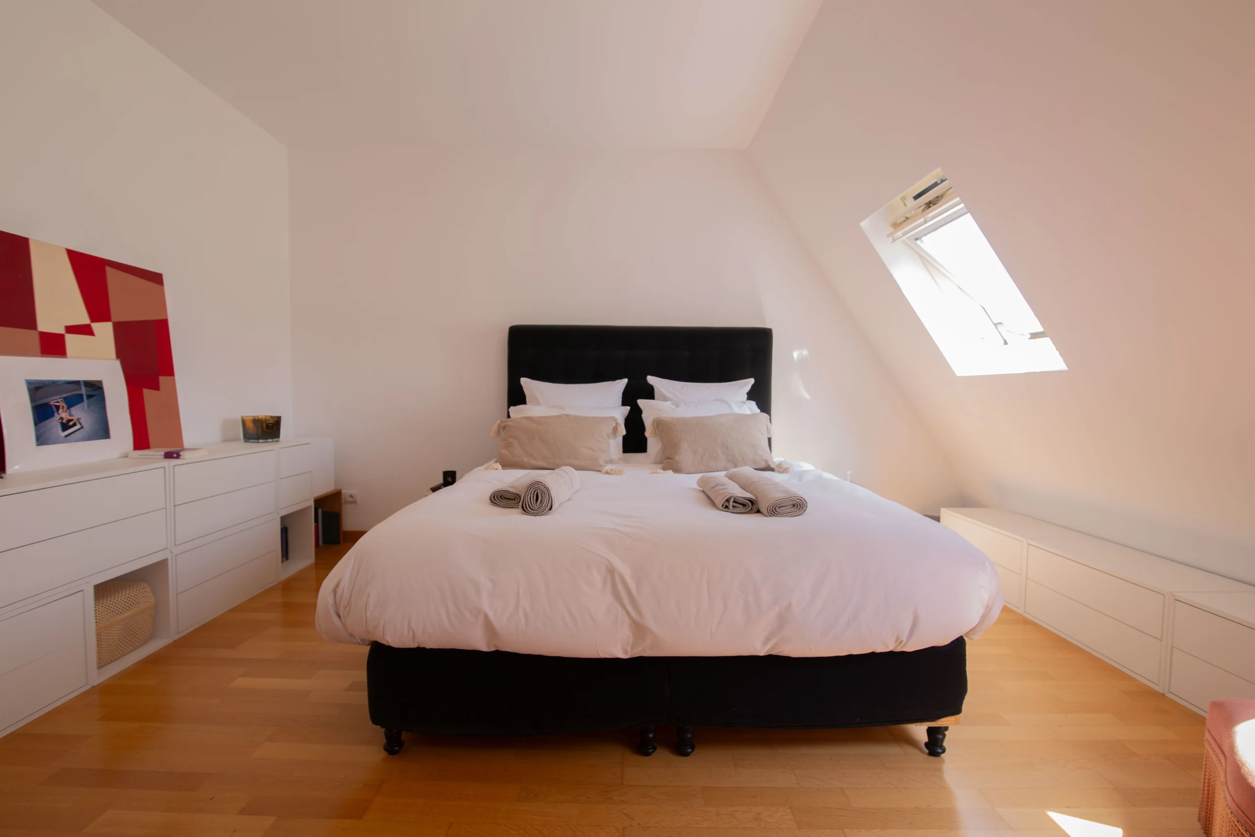 Chambre lumineuse sous pente avec lit double et fenêtre de toit, appartement 90 m² Paris 8e