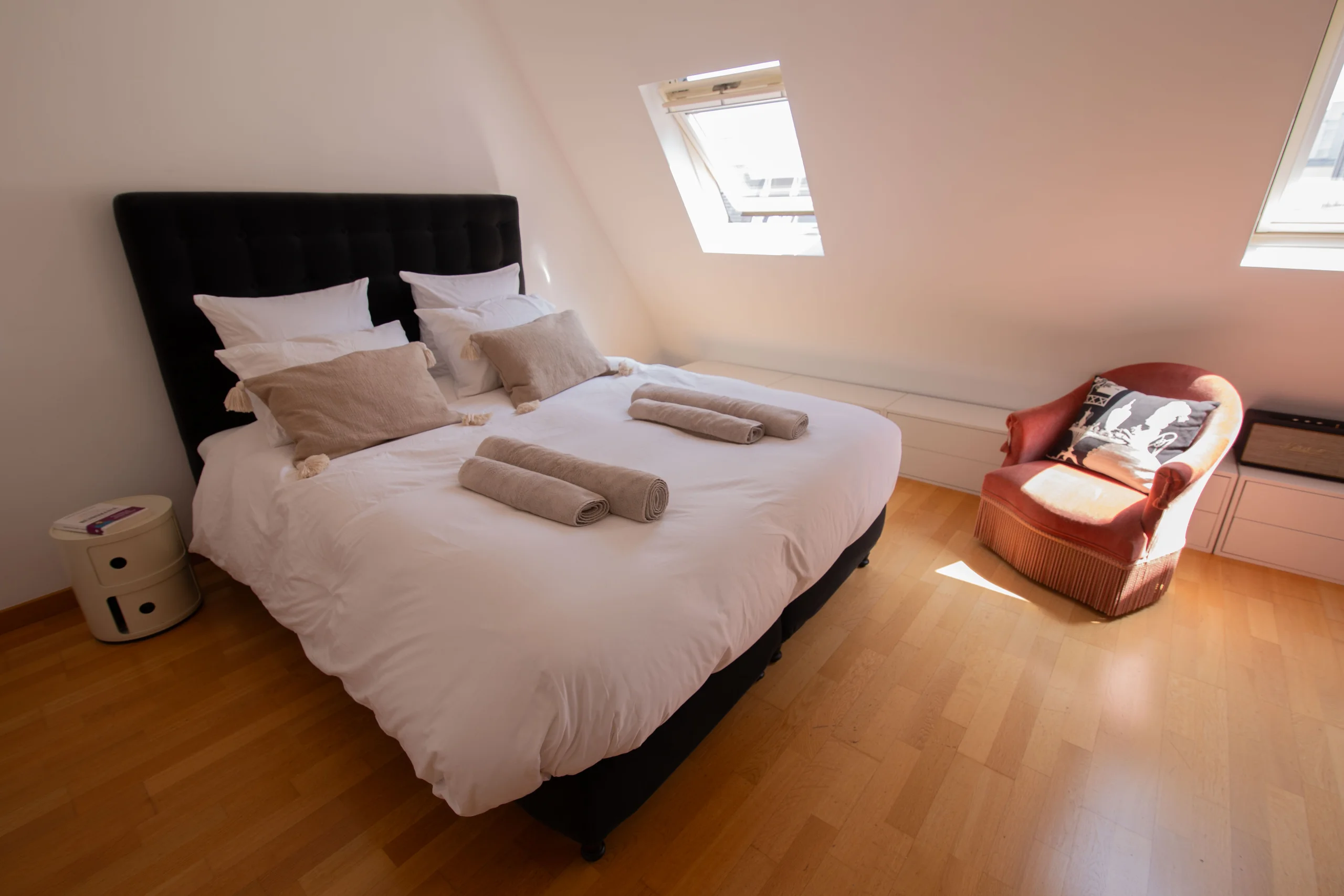 Chambre sous les toits avec lit double et fauteuil crapaud, appartement Triangle d'Or Paris 8e