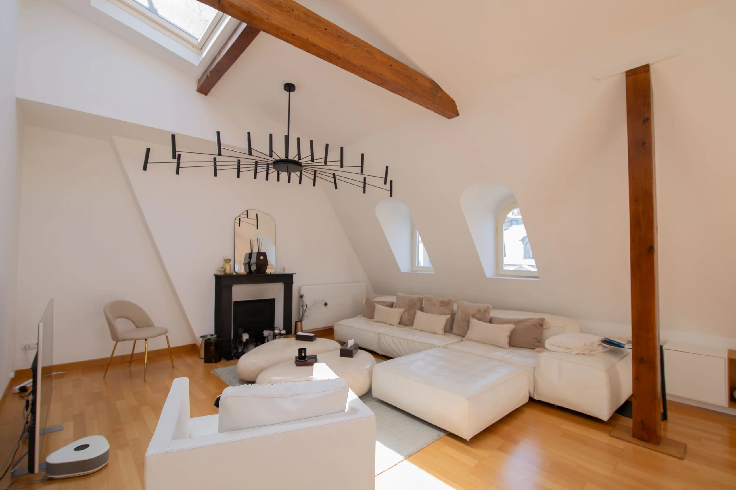 Grand séjour lumineux sous verrière avec poutres et parquet clair, showroom Triangle d'Or