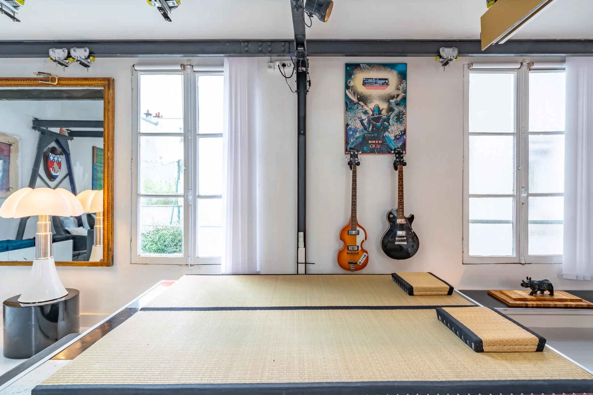 Plateforme aménagée avec tatamis et guitares dans le loft rétro-futuriste de Reuilly-Diderot