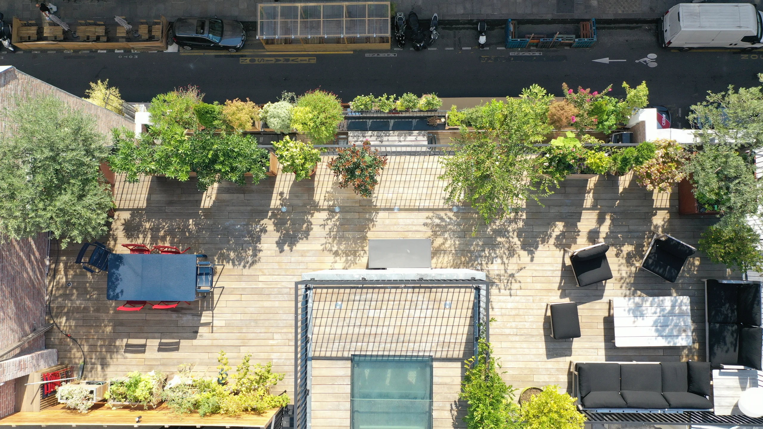 Terrasse rooftop parisienne avec plantes grimpantes, mobilier noir et vue dégagée sur la ville