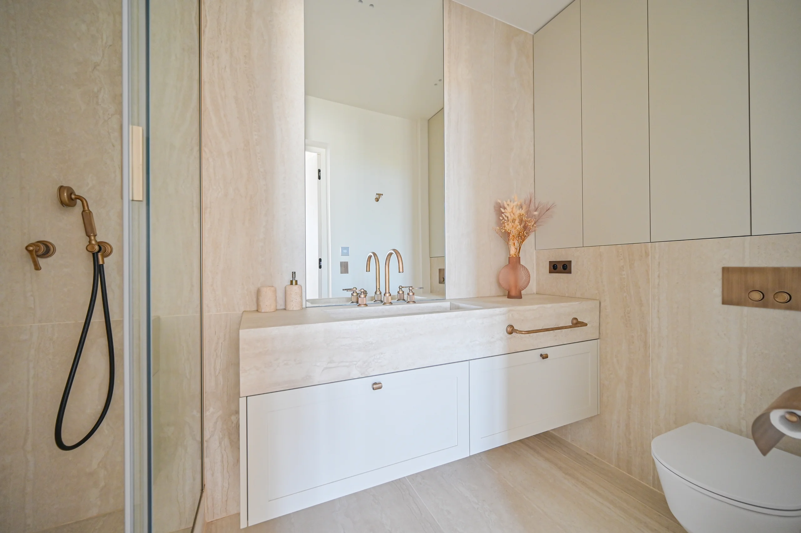 Salle de bains contemporaine aux murs beige clair avec vasque blanche encastrée, miroir large et douche vitrée